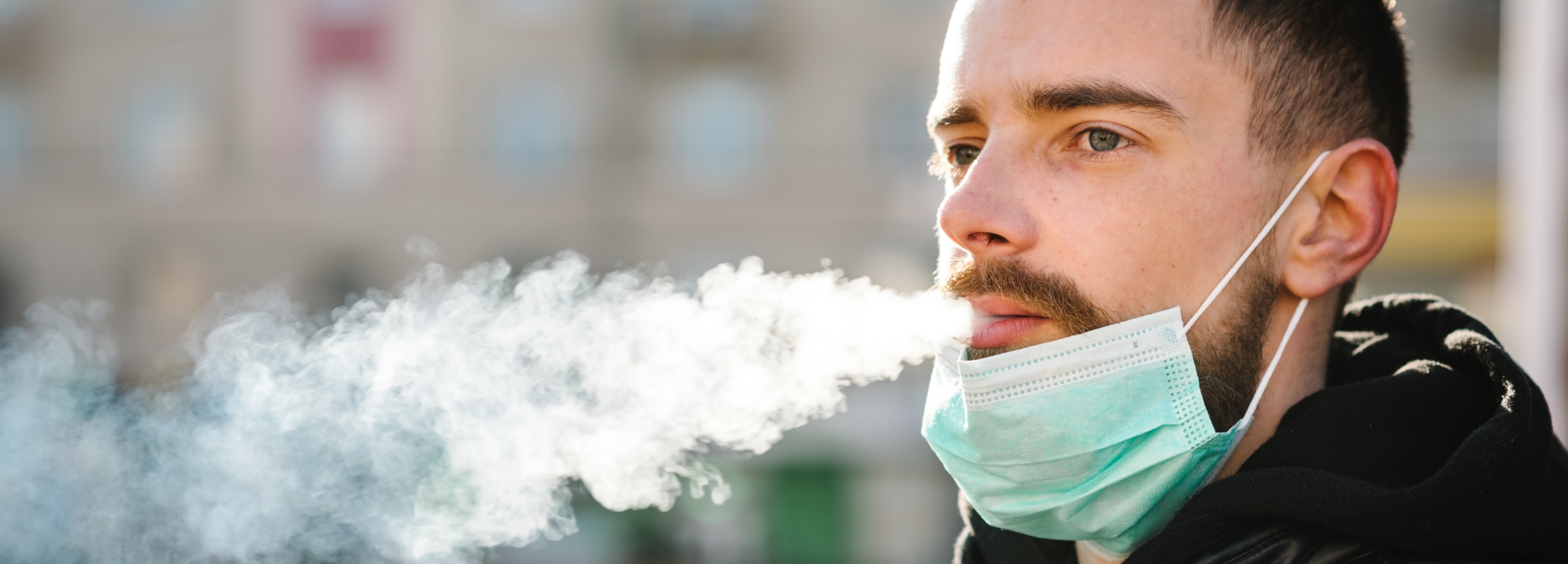 Adult male blowing cigarette smoke.