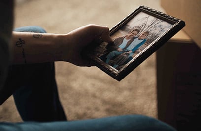 man holding a framed photo of him and his son 2