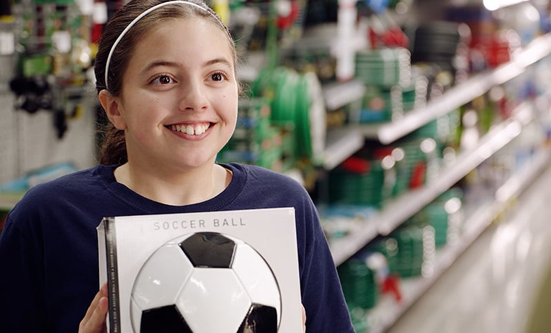 happy child holding a soccer ball in the store