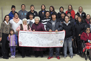 A group of Native American people gathering to display a banner after a policy passsed.
