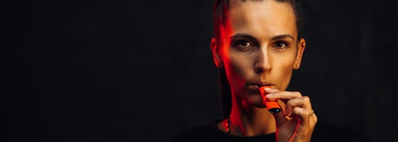 young adult women inhaling a vape pen
