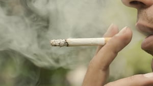 Male adult profile smoking a cigarette.