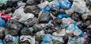 Heaps of trash bags in a landfill.